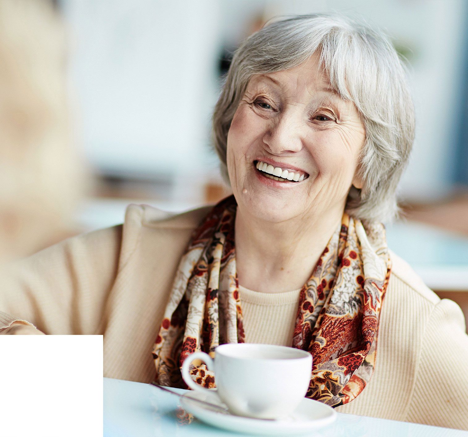 elderly woman smiling with coffee