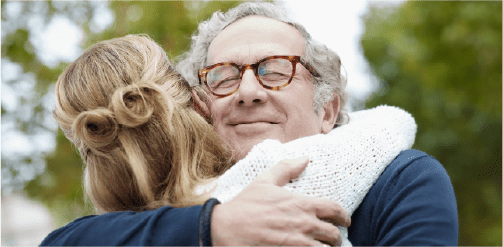 elderly man hugging woman